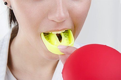 Sports Guards Cosmetic Dentist Endicott | Young woman putting her sports guards | General Dentist Endicott