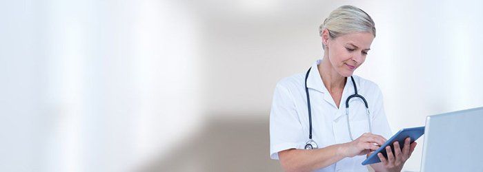 Female doctor working on tablet computer.