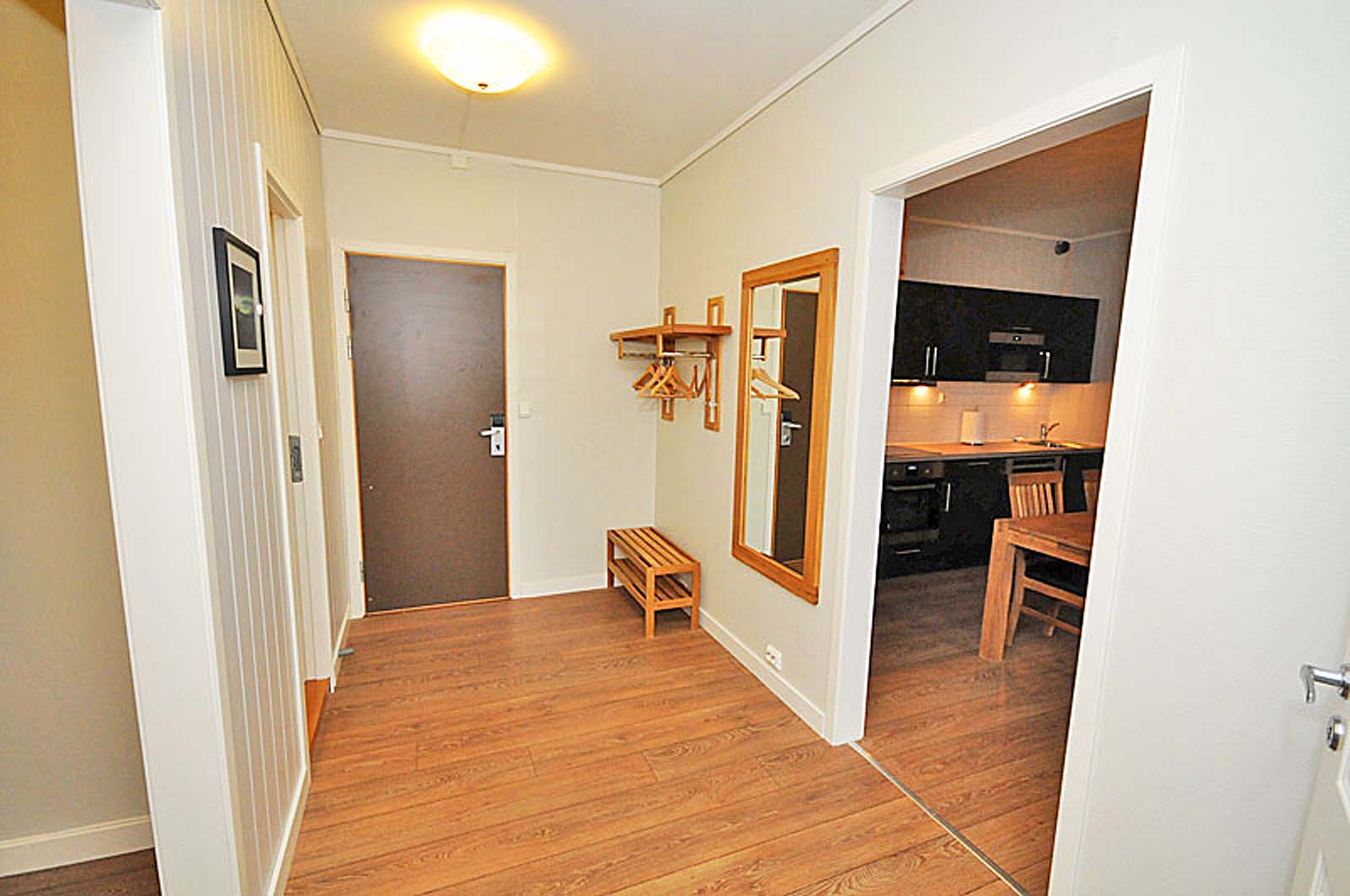 En gang i et hus med tregulv og speil.