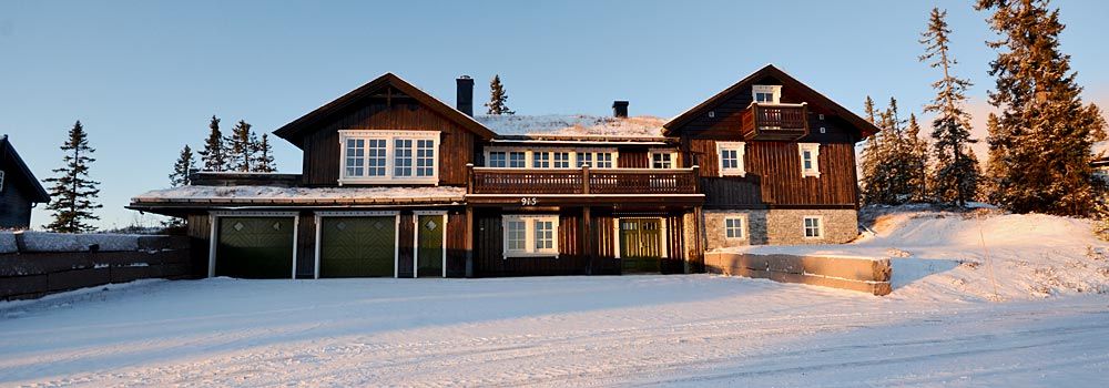 Et stort hus sitter på toppen av en snødekket bakke.