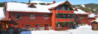 En stor rød bygning med snø på taket