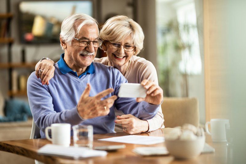 Old Couple Having a Video Chat Over Smart Phone — Fort Wayne, IN — Lederman Insurance, Inc.