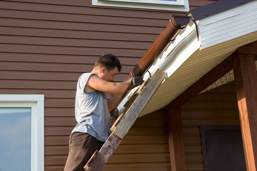 man on the ladder reaching the roof