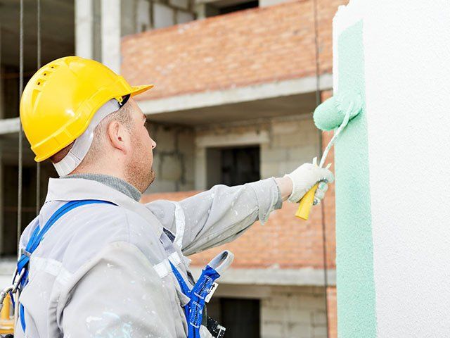 Worker Painting Facade Of High Rise Building — Classic Coatings Australia In Hervey Bay QLD Worker Painting Facade Of High Rise Building — Classic Coatings Australia In Hervey Bay QLD