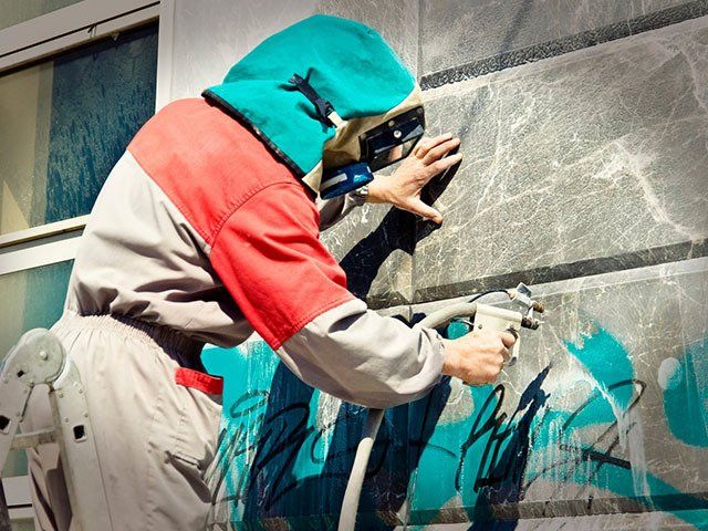 Cleaning Graffiti From A Building Wall — Classic Coatings Australia In Hervey Bay QLD Cleaning Graffiti From A Building Wall — Classic Coatings Australia In Hervey Bay QLD