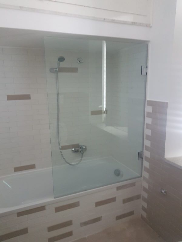 vasca da bagno con pannello in vetro opaco