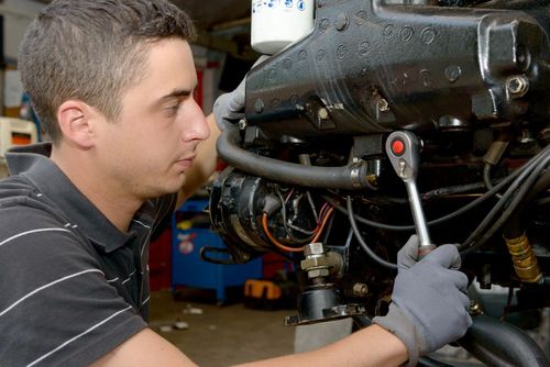 Boat Repairs — Man Repairing Motor Boat in Newberg, OR