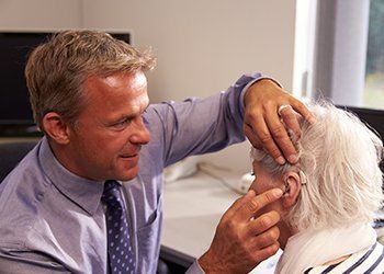 Hearing Healthcare Repairs — Doctor Checking the Hearing Aid Device in Pottstown, PA Hearing Healthcare Repairs — Doctor Checking the Hearing Aid Device in Pottstown, PA