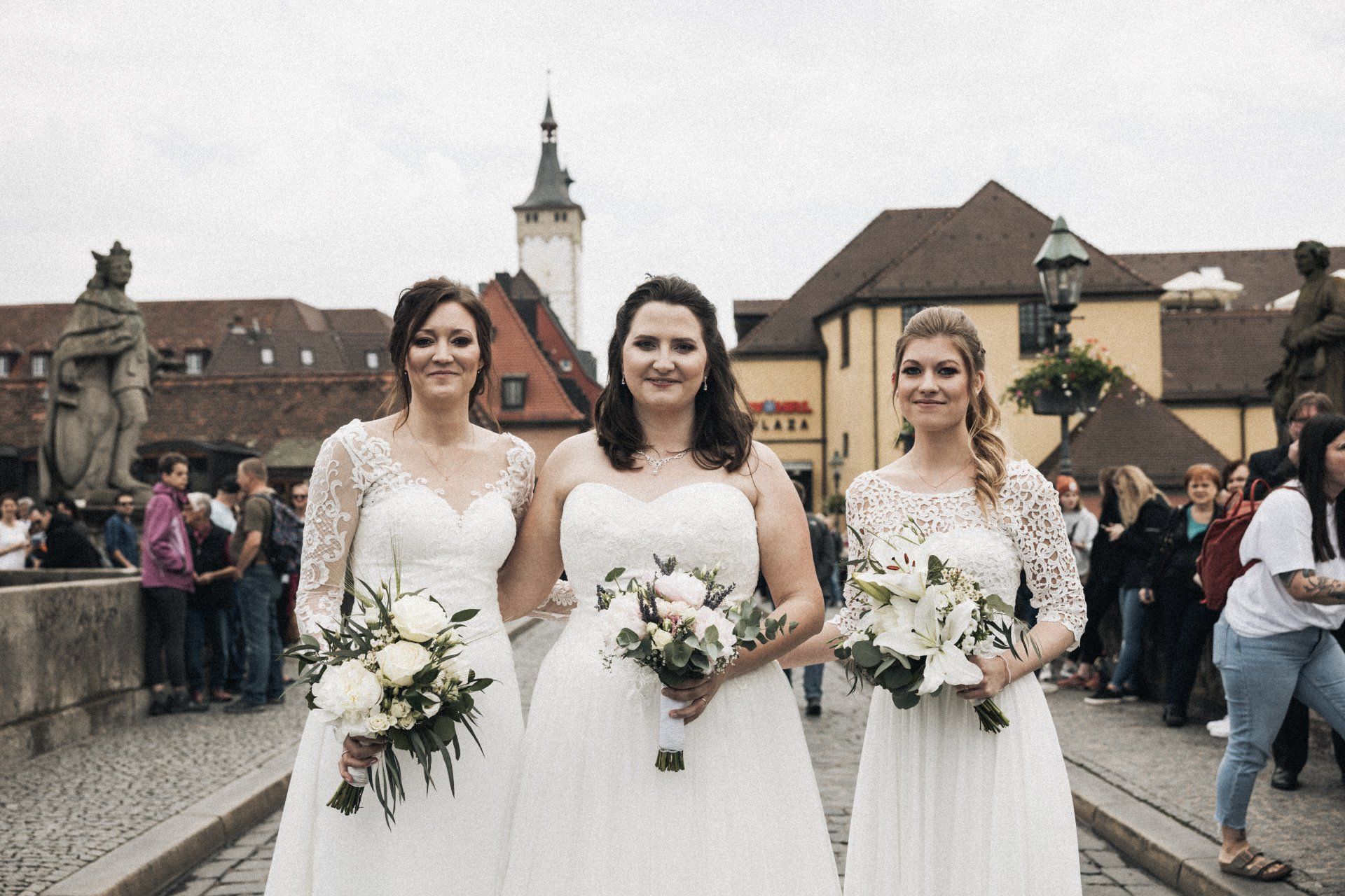 Drei Frauen in weißen Kleidern posieren für ein Foto.