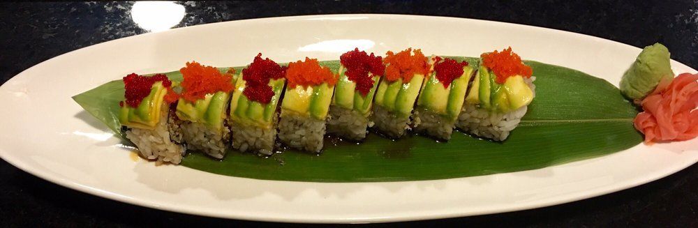 A Lightning Roll sushi roll topped with sliced avocado and fish roe.