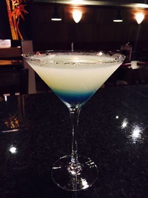 Layered blue and white cocktail served in a martini glass