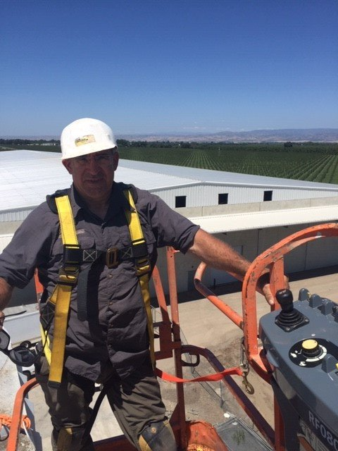 Worker installing chimney on roof top — Los Molinos, CA — North Valley Cleaning Worker installing chimney on roof top — Los Molinos, CA — North Valley Cleaning