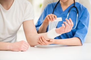 Physical Therapy Appointment — Doctor Bandaging Hand of Male Patient in Natick, MA Physical Therapy Appointment — Doctor Bandaging Hand of Male Patient in Natick, MA