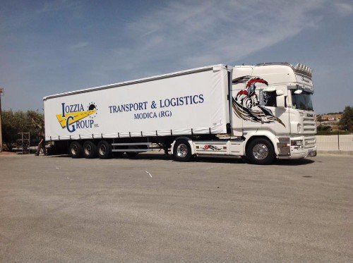 Un tir con un rimorchio con scritto Iozzia Group transport & logistics