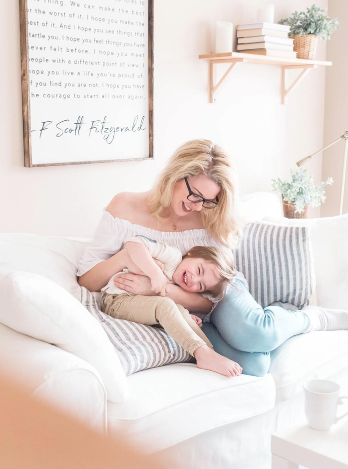 mother and son happy playing on a couch inside a clean house