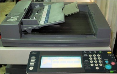 Fotocopiatrice grigia con monitor attivo