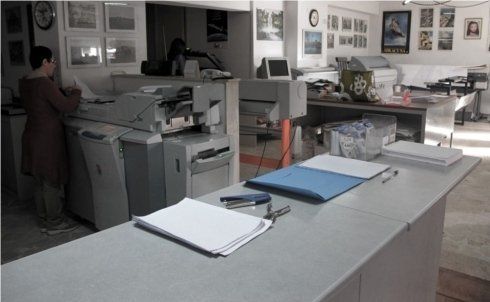 Interni di una copisteria con documenti sul bancone grigio