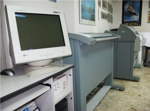 Postazione pc con computer bianco e fotocopiatrici grigie