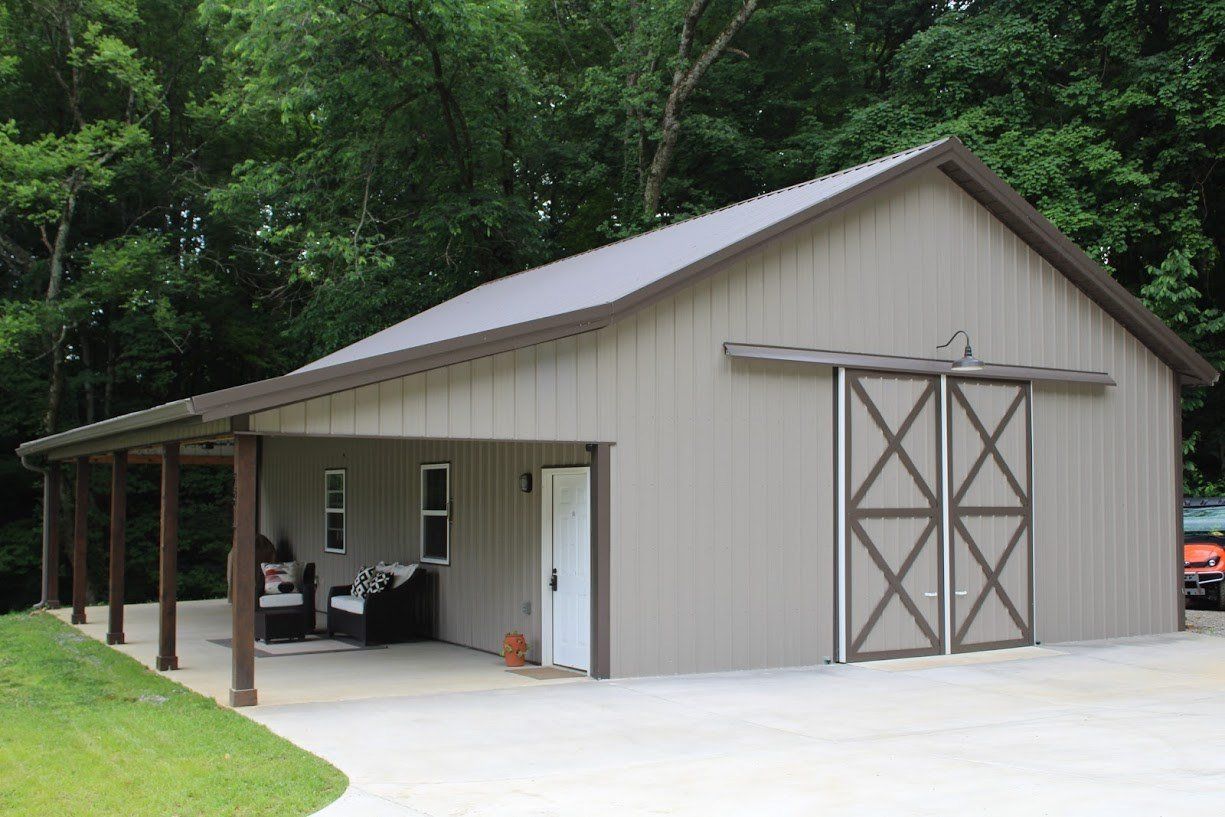 Tan garage with one door and five beams on a concrete slab