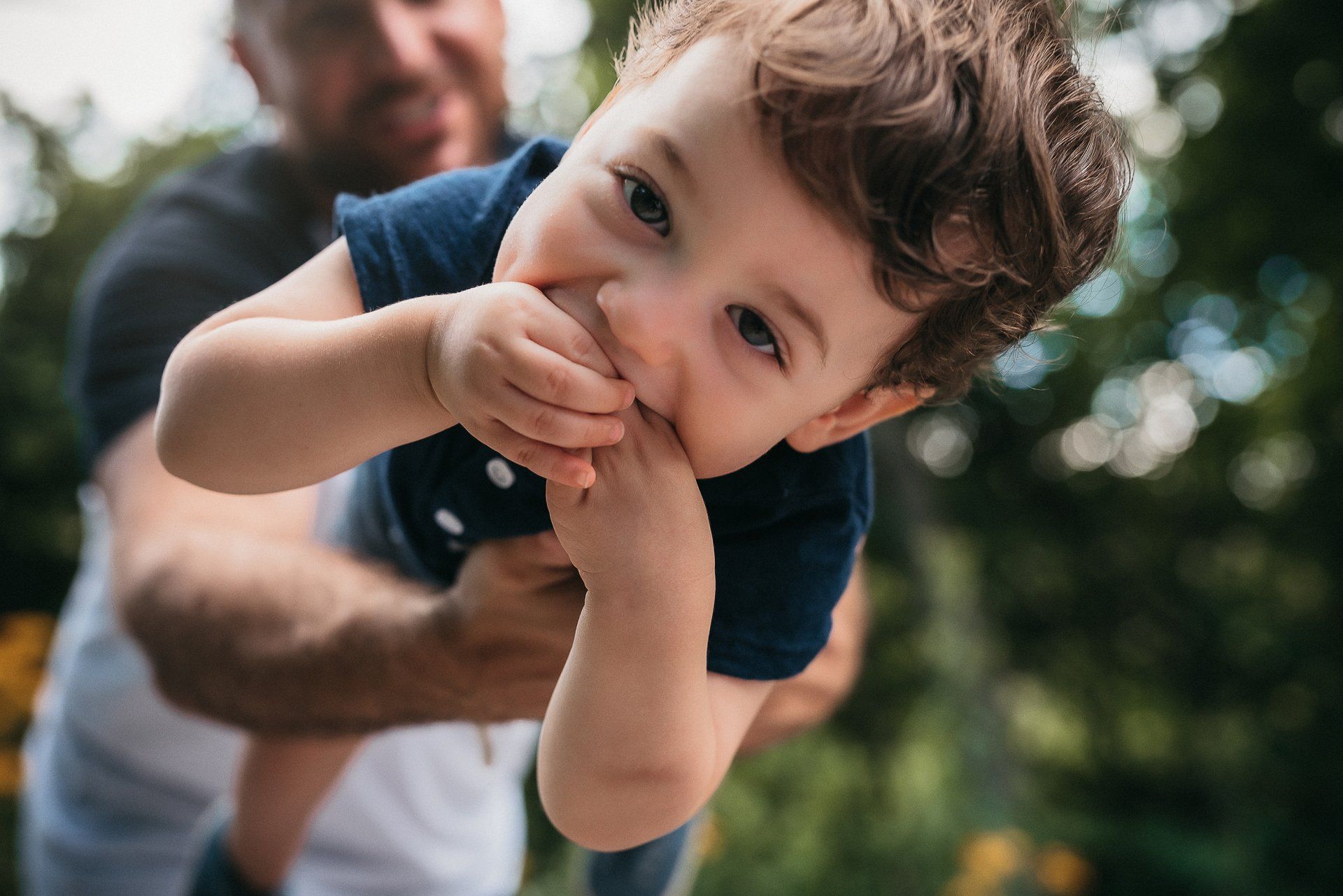 Photo of a father holding his smiling son for family photoshoot gift