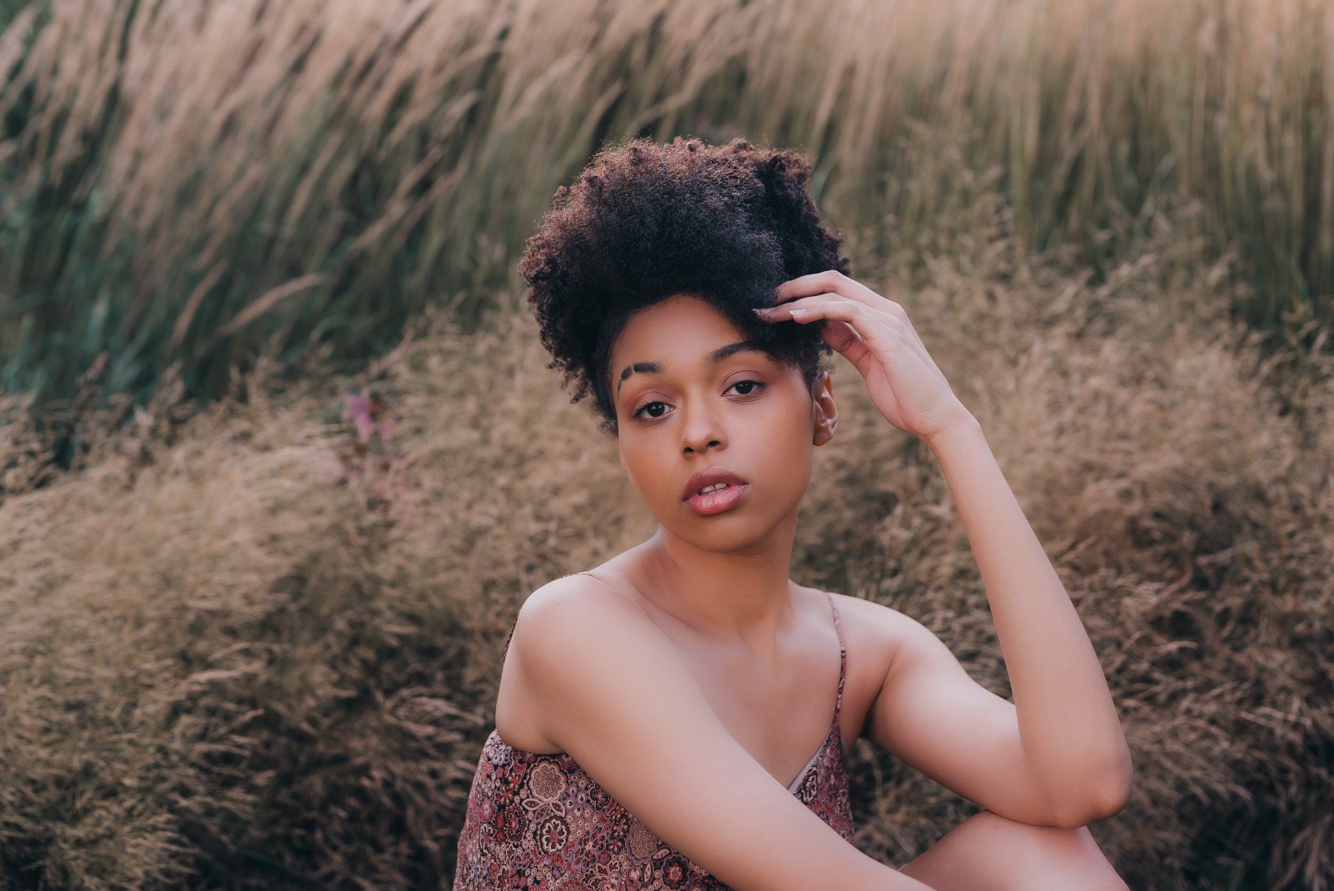Young woman sitting in field for personal branding gift card