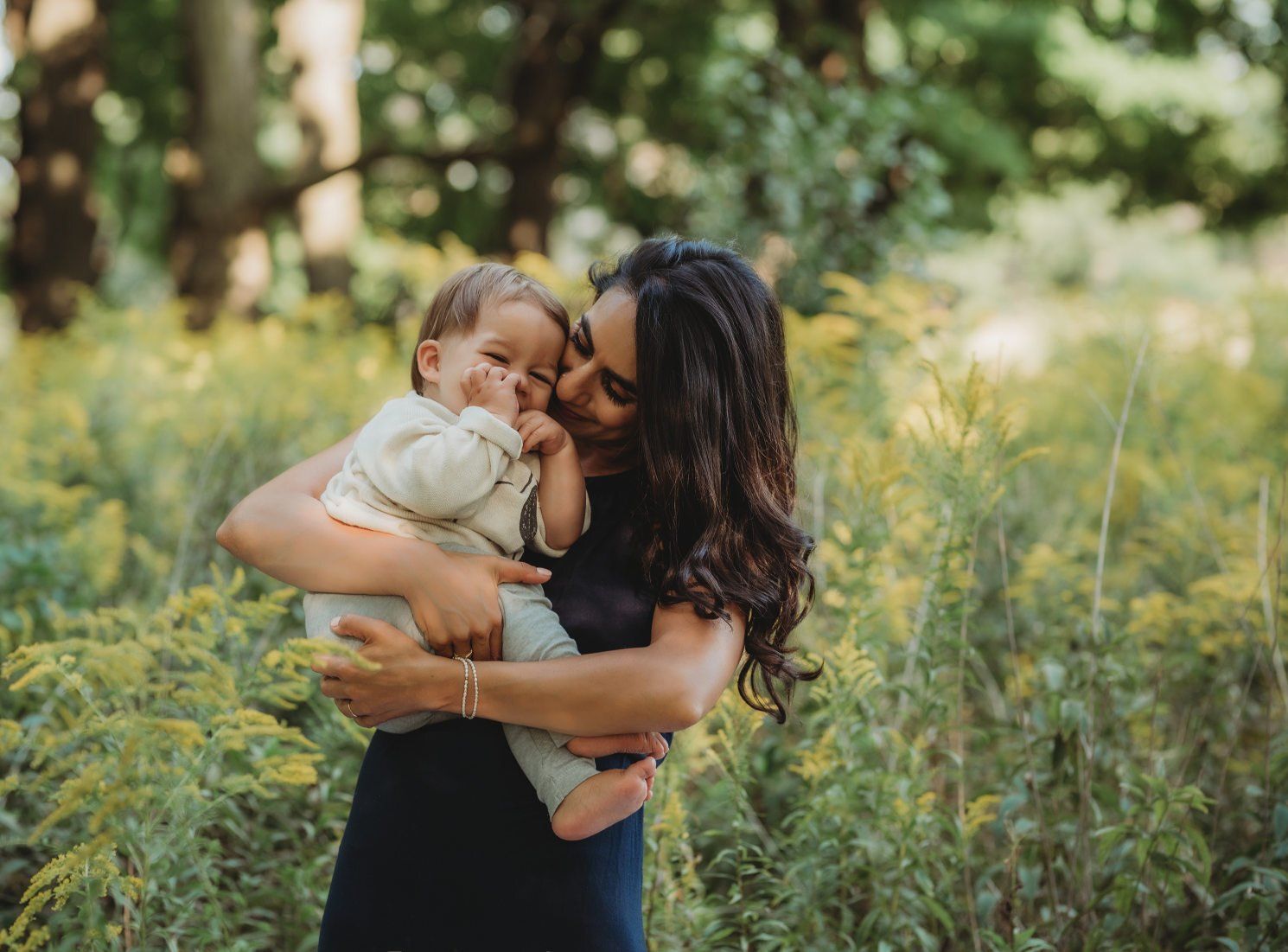 Mother holding baby in field for fall photoshoot