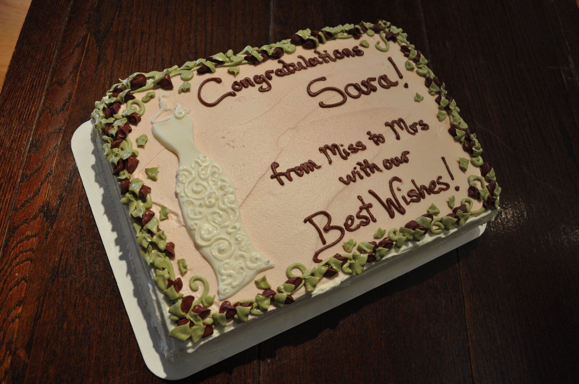 A cake that says congratulations sara from miss to mrs with our best wishes