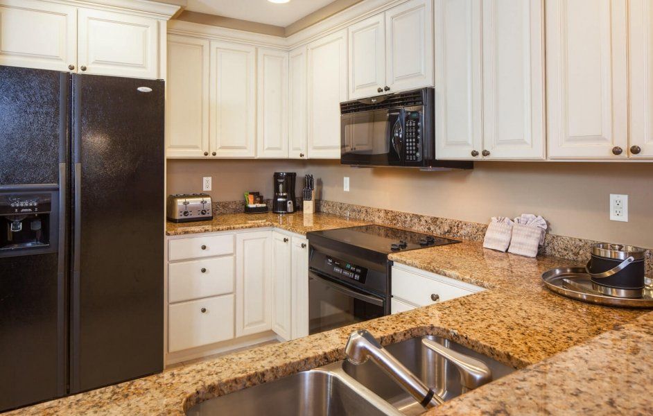 Modern kitchen with white cabinets, black appliances, and granite countertops