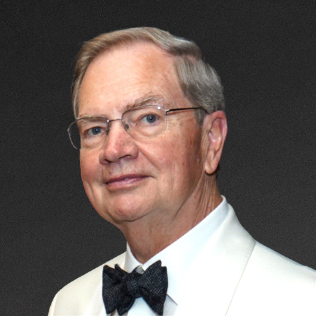 Formal portrait of a man in a white tuxedo jacket and black bow tie against a dark background