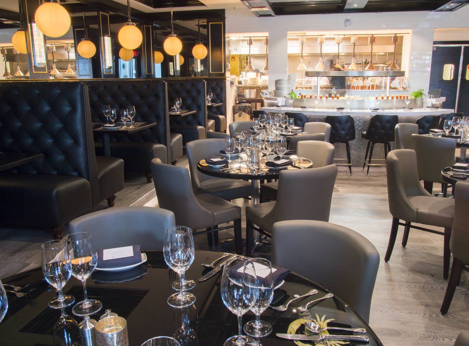Elegant restaurant interior with black tables, gray chairs, and warm pendant lighting