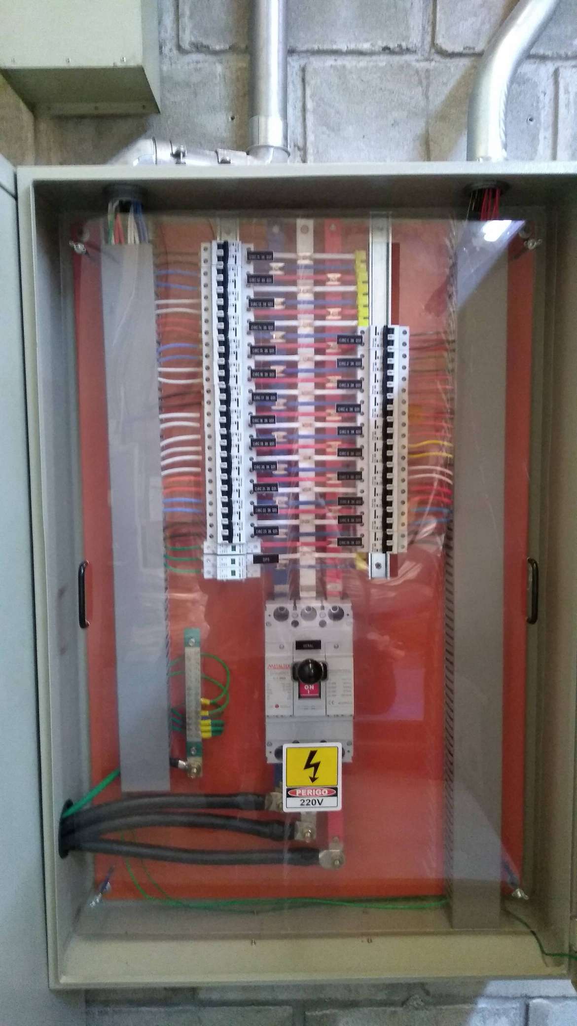 Painel de controle elétrico aberto com fileiras de disjuntores e fiação em um gabinete de metal.