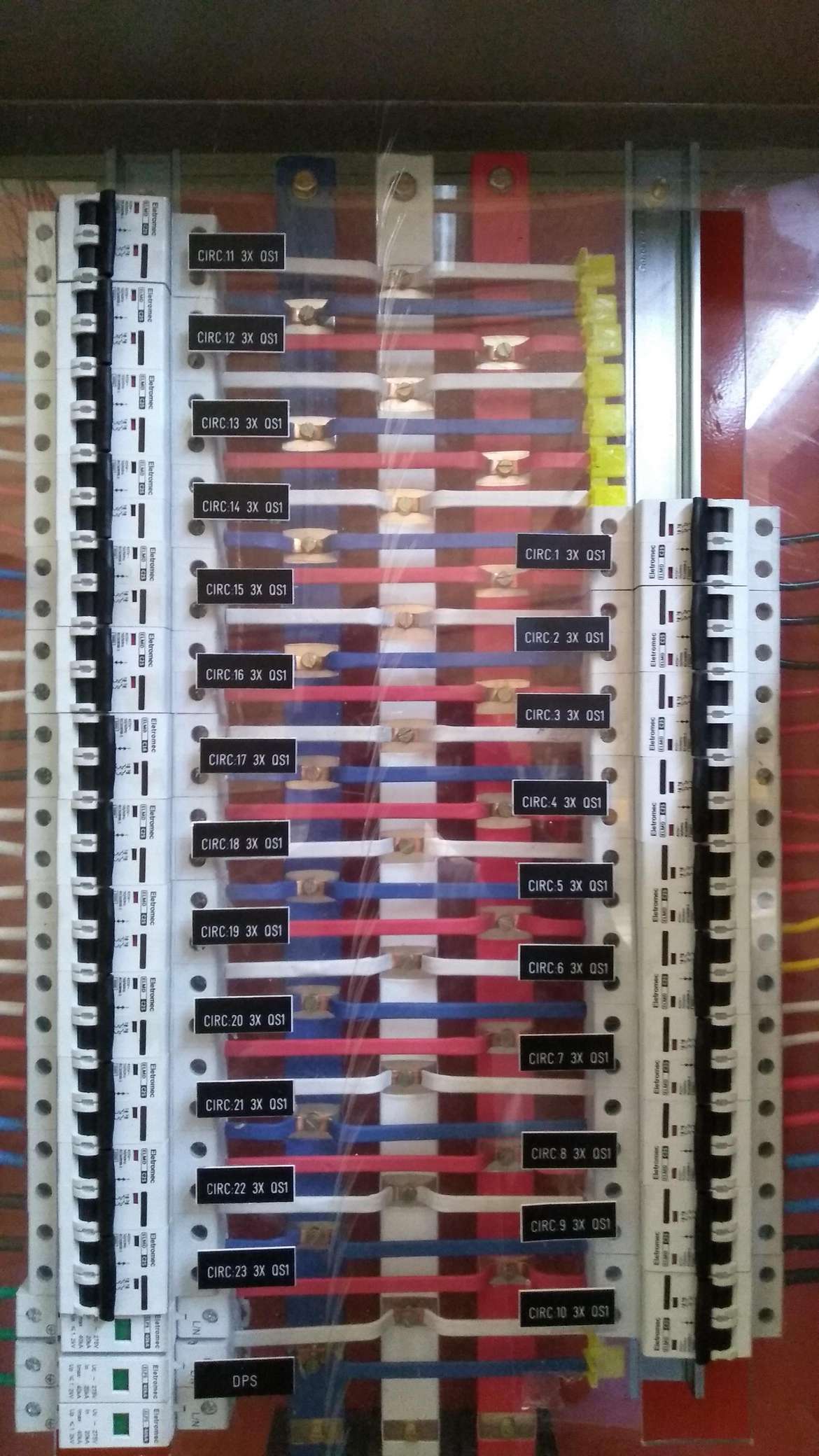 Painel elétrico com vários disjuntores e fiação colorida dentro de um gabinete aberto.