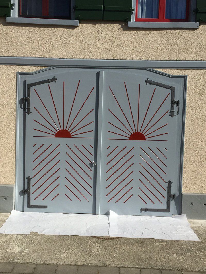 Ein Paar Garagentore mit einem Sonnenmotiv darauf