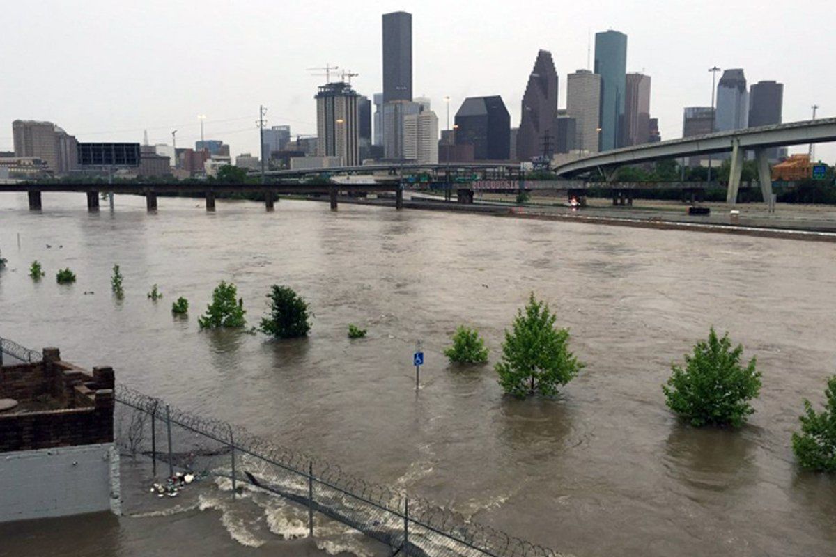 A flooded river with a city skyline in the background.