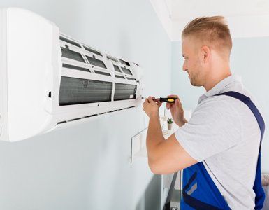 HVAC Maintenance — Repairman Fixing Air Conditioner in Port Lavaca, TX HVAC Maintenance — Repairman Fixing Air Conditioner in Port Lavaca, TX