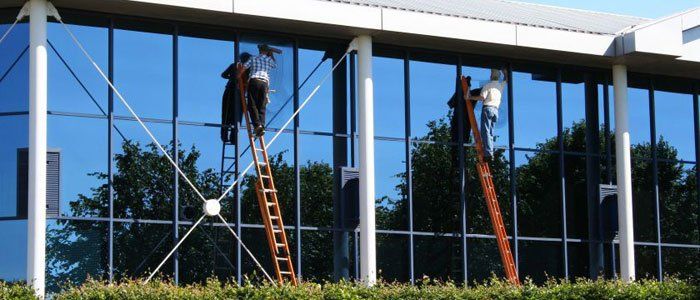 Two Workers Cleaning a Building Window — Monterey, CA — Better View Window Cleaners Two Workers Cleaning a Building Window — Monterey, CA — Better View Window Cleaners