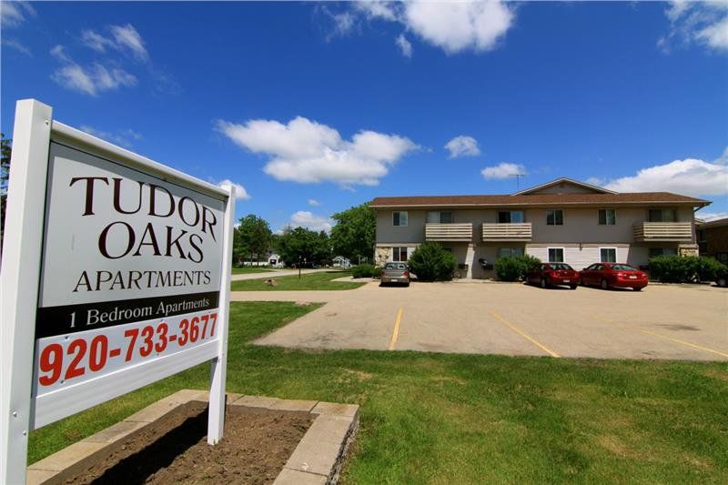 The sign outside of Tudor Oaks Apartments with a contact phone number
