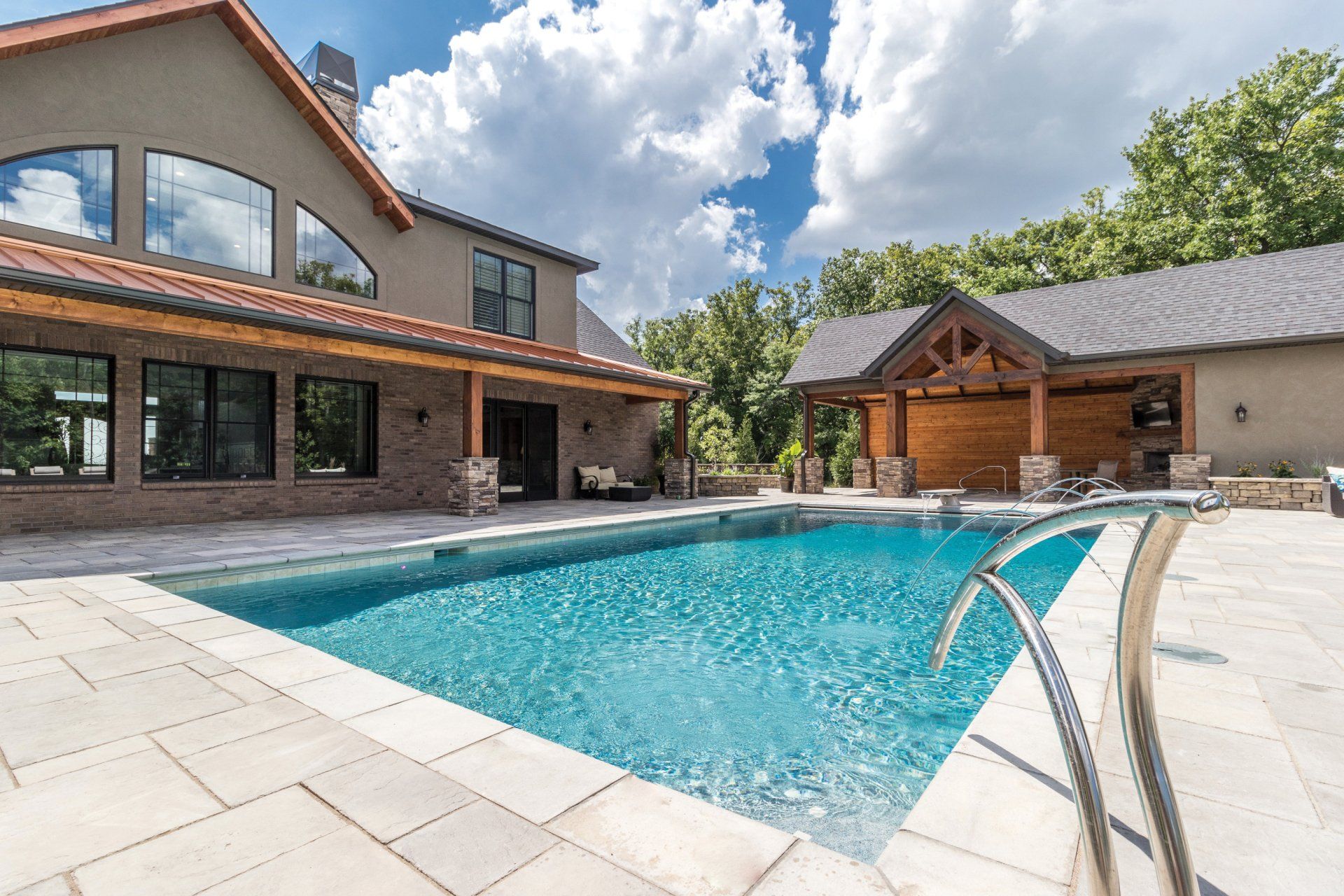 A large house with a large swimming pool in front of it.