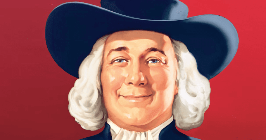 Um homem está usando um chapéu de cowboy e sorrindo.