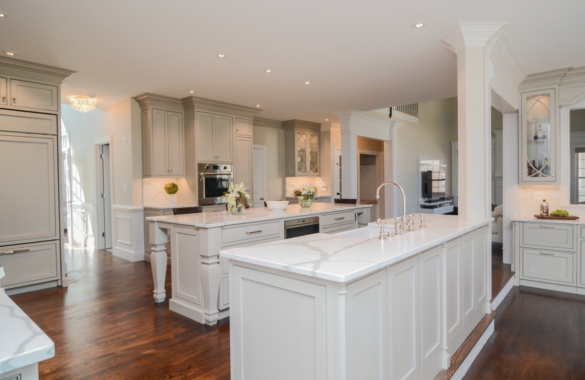Bright white modern kitchen with island, pendant lights, and hardwood floors