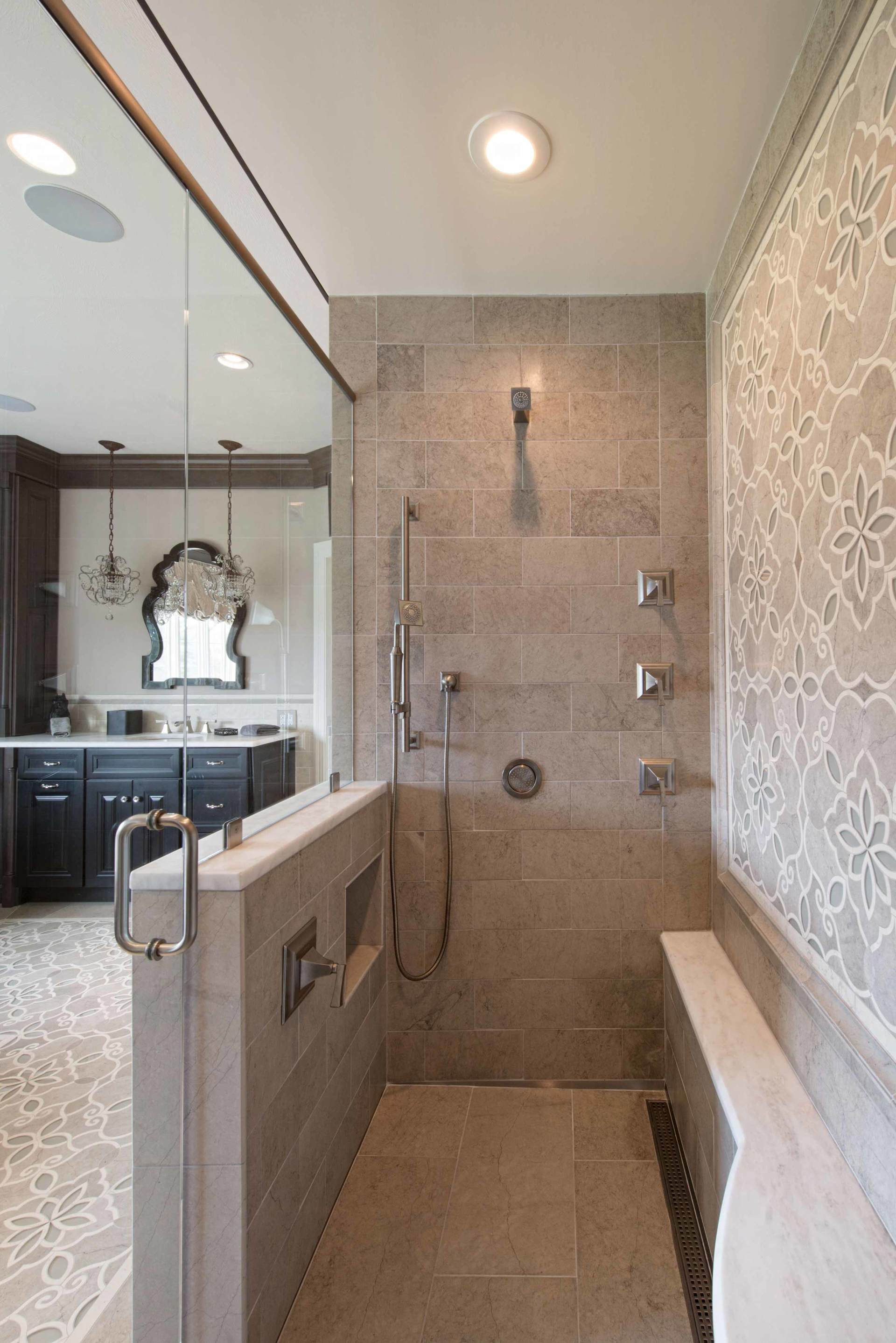 Bathroom with a glass shower, beige tile, and patterned wallpaper beside a white tub.