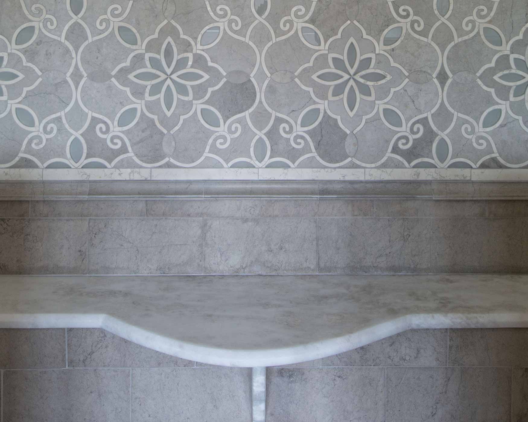 Ornate floral wallpaper above a gray upholstered headboard with a curved lower edge