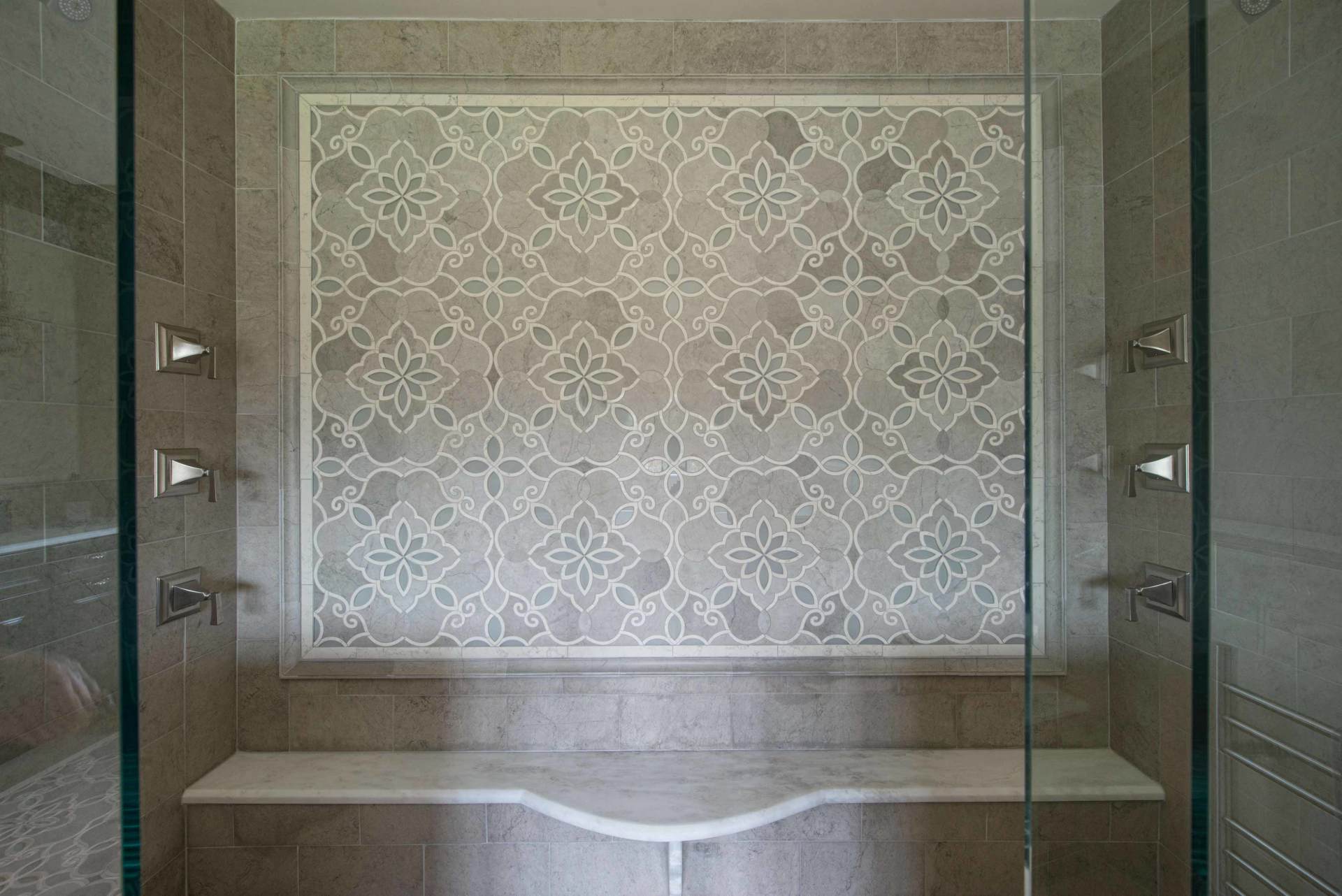 Empty tiled alcove with a built-in bathtub and patterned wall paneling