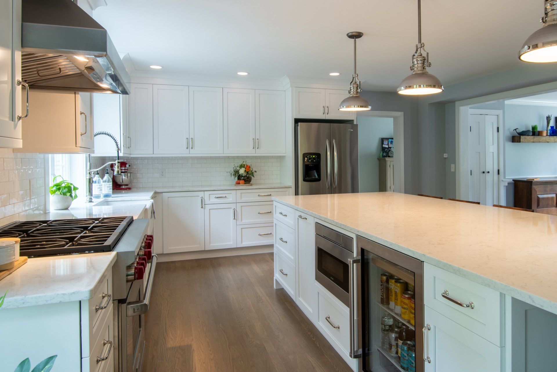 Bright modern kitchen with white cabinets, large island, stainless appliances, and pendant lights