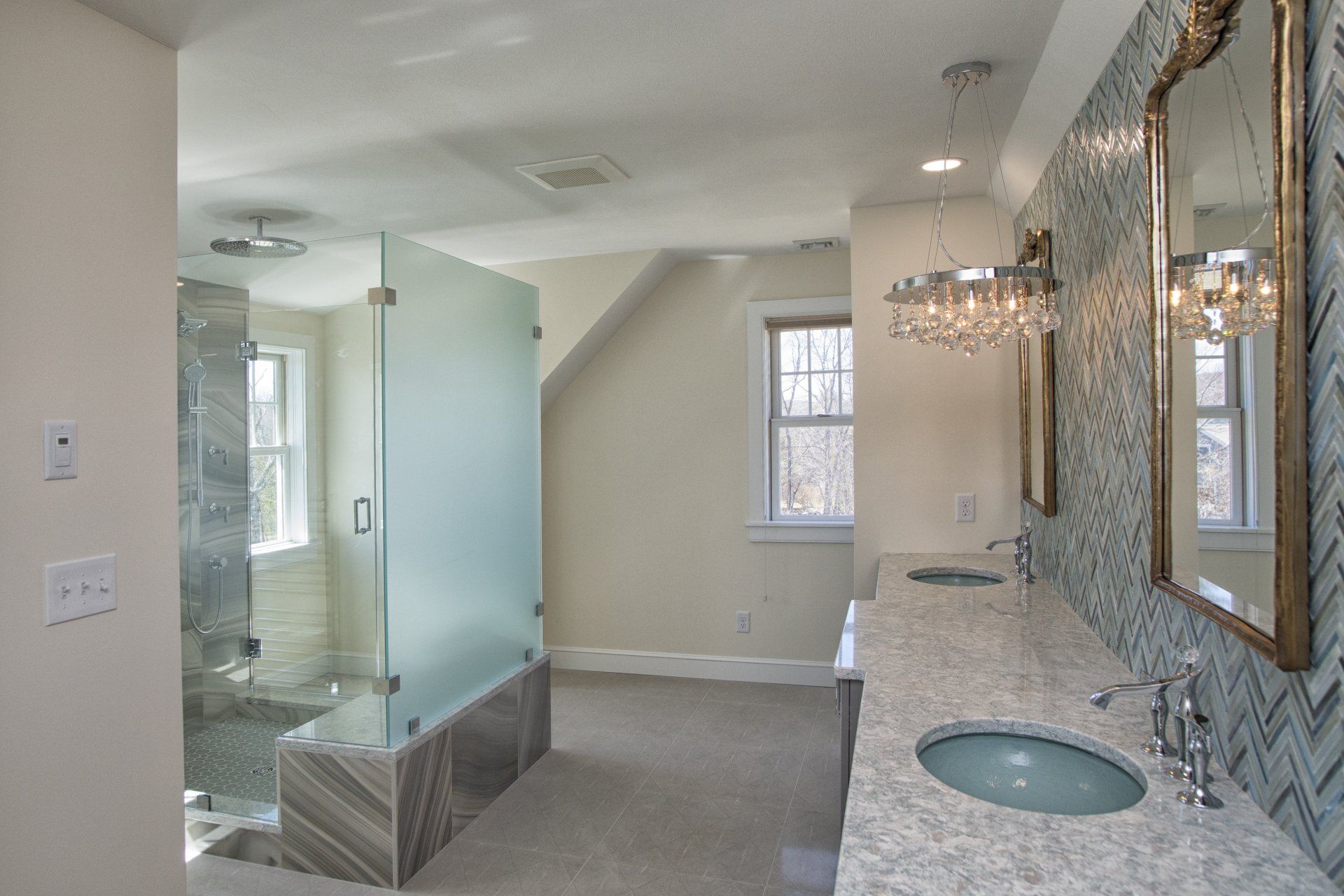 Modern bathroom with glass shower, marble vanity, and a large mirror