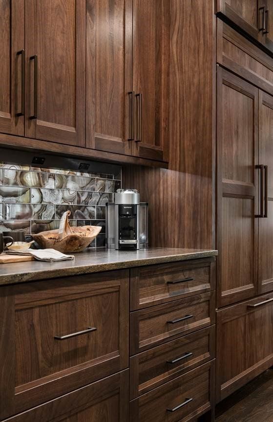 Wooden kitchen cabinets and countertop with coffee maker and pastries in a modern kitchen