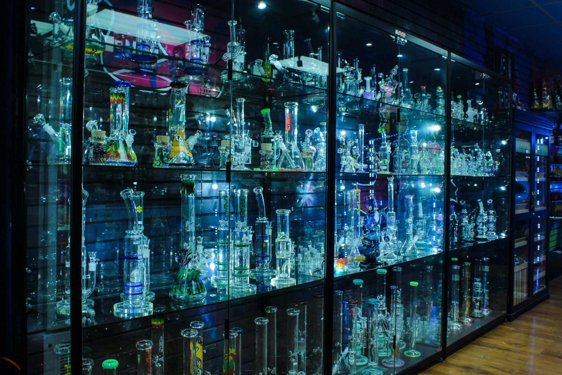 A glass case filled with lots of glass pipes and bongs.