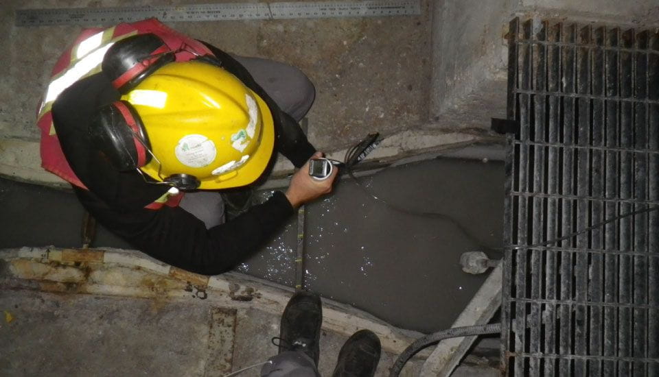 Un homme portant un casque jaune travaille sur une pipe.