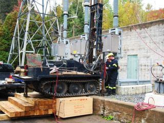 Un homme se tient à côté d’une machine qui se trouve sur une remorque.