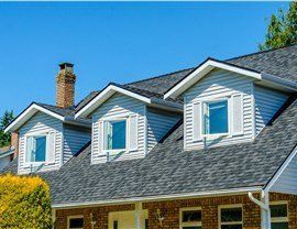 A house with three dormers and a chimney on the roof.